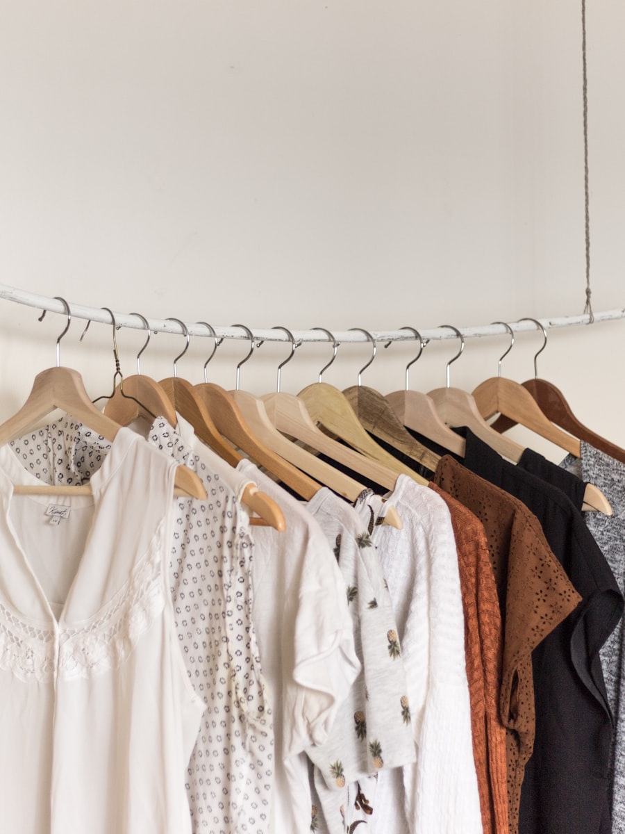 A rail of ivory and sand garments on wooden hangers